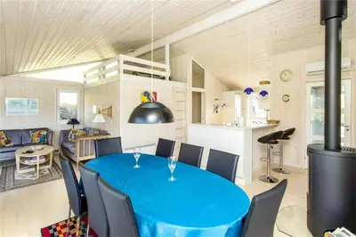 a dining room and kitchen with a blue table and chairs at BL289-Blokhus-Moreavej-41 in Blokhus