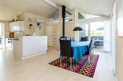 a dining room with a blue table and chairs at BL289-Blokhus-Moreavej-41 in Blokhus