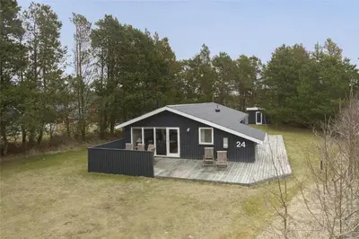 a black tiny house on a deck in a field at BL489-Pandrup-Rodhusparken-24 in Pandrup