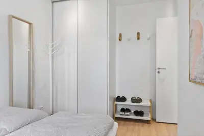 a bedroom with two beds and a closet with shoes on a shelf at BL1708-Blokhus-Klitgaardsvej-3-D in Blokhus