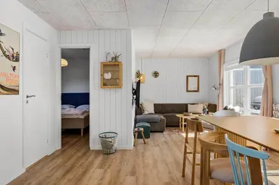 a kitchen and living room with a table and a couch at BL1209-Blokhus-Bellevueparken-14 in Blokhus