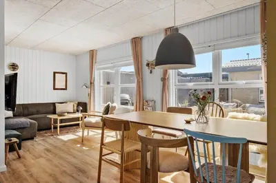a kitchen and living room with a table and chairs at BL1209-Blokhus-Bellevueparken-14 in Blokhus
