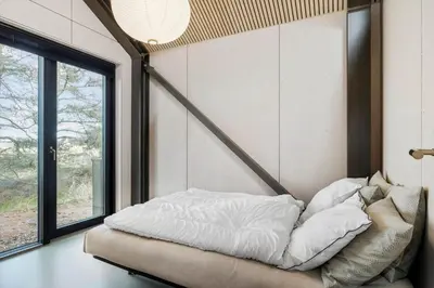 a bed in a room with a large window at BL1327-Blokhus-Braendevinsstien-5 in Blokhus