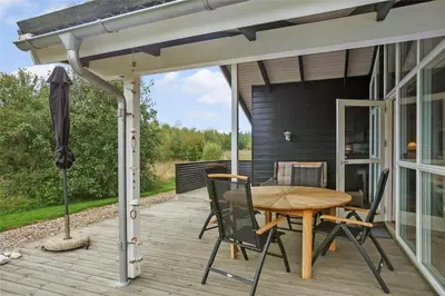 a patio with a table and chairs and an umbrella at BL757-Saltum-Tolhoj-12 in Saltum