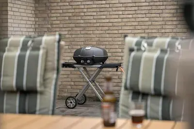 a grill sitting on a table in front of a brick wall at BL1359-Blokhus-Bellevueparken-24 in Blokhus