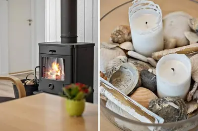 a fireplace sitting on a table next to a table with candles at BL1359-Blokhus-Bellevueparken-24 in Blokhus