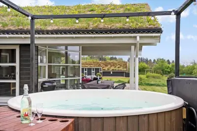 a hot tub on a patio with a pergola at BL497-Saltum-Tolhoj-4 in Saltum