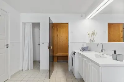 a white bathroom with a sink and a mirror at BL1443-Blokhus-Ferren-Syd-46 in Blokhus