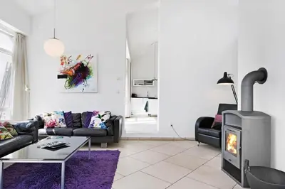 a living room with a couch and a fireplace at BL1480-Blokhus-Ferren-51 in Blokhus