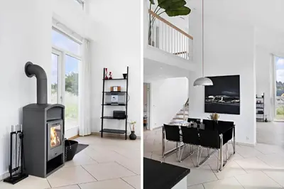 a living room with a fireplace and a dining room at BL1480-Blokhus-Ferren-51 in Blokhus