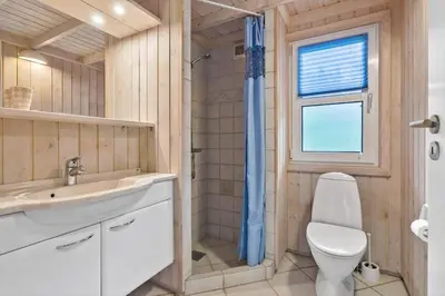 a bathroom with a toilet and a sink and a window at BL295-Saltum-Graabakken-2 in Saltum