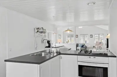 a white kitchen with a sink and a counter top at BL395-Blokhus-Maren-Hjortelsvej-4 in Blokhus