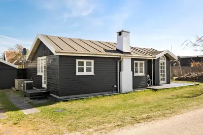 a small black house with a roof at BL395-Blokhus-Maren-Hjortelsvej-4 in Blokhus