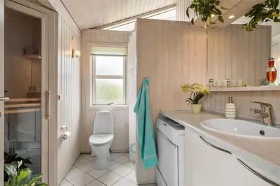 a bathroom with a sink and a toilet and a window at BL330-Blokhus-Lyngvej-2 in Blokhus