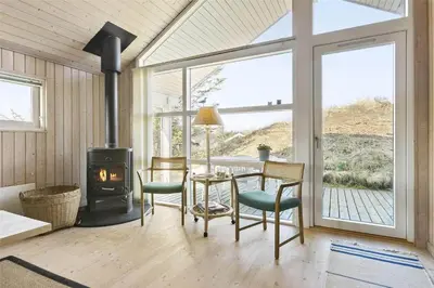 a living room with a table and a wood stove at BL401-Blokhus-Lyngvej-12 in Blokhus