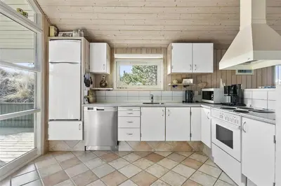 a white kitchen with white appliances and a window at BL401-Blokhus-Lyngvej-12 in Blokhus