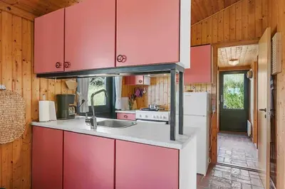 a kitchen with red cabinets and a white refrigerator at BL1308-Saltum-Kordalsvej-124 in Saltum
