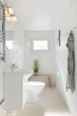 a white bathroom with a toilet and a sink at BL1729-Blokhus-Jens-Baerentsvej-36 in Blokhus