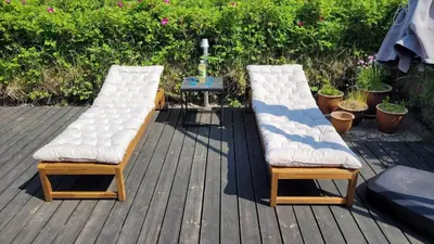 two benches with white cushions sitting on a deck at BL1729-Blokhus-Jens-Baerentsvej-36 in Blokhus