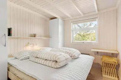 two beds in a white room with a window at BL1461-Saltum-Kvansletten-29 in Saltum
