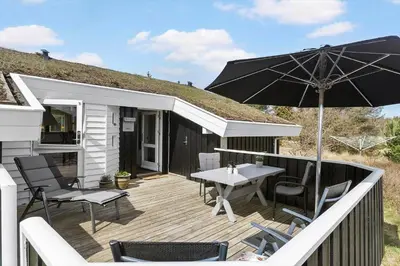 a patio with an umbrella and a table and chairs at BL1461-Saltum-Kvansletten-29 in Saltum