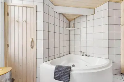 a bath tub in a bathroom with white tiles at BL1461-Saltum-Kvansletten-29 in Saltum