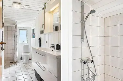 a white bathroom with a shower and a sink at BL1366-Blokhus-Berberisvej-56 in Blokhus
