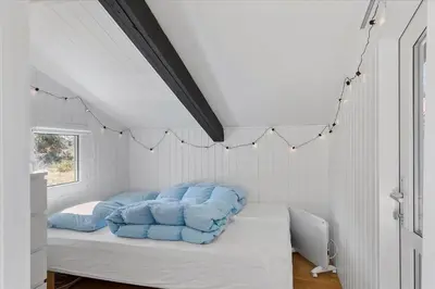 a bedroom with a bed with blue pillows on it at BL794-Pandrup-Hunetorp-Klitvej-113 in Pandrup