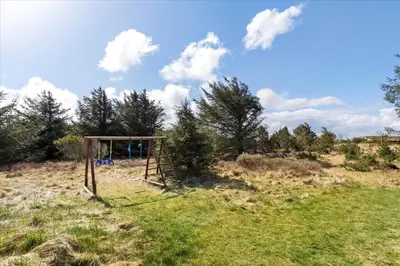 a playground in the middle of a field with trees at BL794-Pandrup-Hunetorp-Klitvej-113 in Pandrup