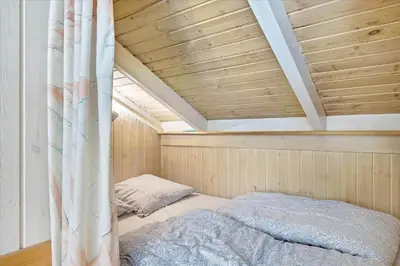 a bed in a room with a wooden ceiling at BL565-Pandrup-Lunekrogen-22 in Pandrup