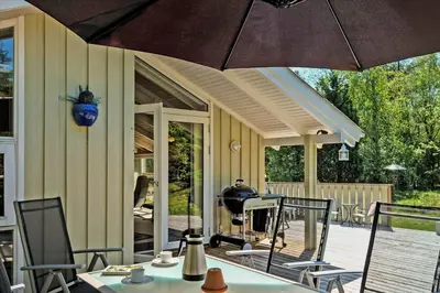 a patio with a table and chairs and an umbrella at BL565-Pandrup-Lunekrogen-22 in Pandrup