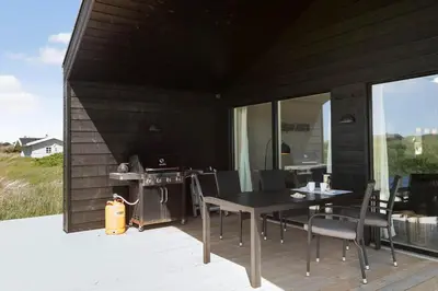 a patio with a table and chairs on a deck at BL1481-Saltum-Kommenvej-1 in Saltum
