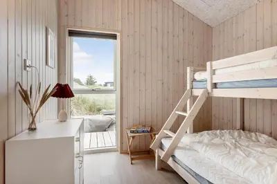 a bedroom with two bunk beds and a window at BL1481-Saltum-Kommenvej-1 in Saltum