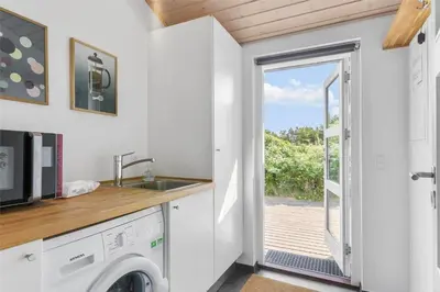 a kitchen with a washer and dryer in a tiny house at BL747-Saltum-Graabakken-7 in Saltum