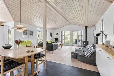 a kitchen and living room with a wooden ceiling at BL747-Saltum-Graabakken-7 in Saltum