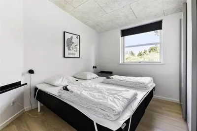 a bedroom with two beds and a window at BL1110-Blokhus-Bloksbjerg-7 in Blokhus