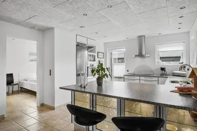 a kitchen with a counter and two stools in it at BL1509-Blokhus-Stromsvej-7 in Blokhus