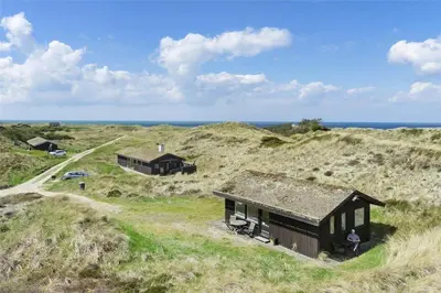 a house on a hill with the ocean in the background at BL808-Pandrup-Hare-hop-5 in Pandrup