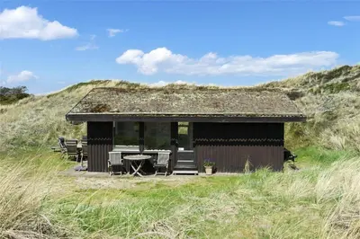 a building with a table and chairs in a field at BL808-Pandrup-Hare-hop-5 in Pandrup