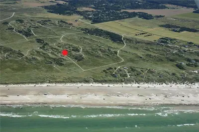 a red frisbee is flying over the beach at BL808-Pandrup-Hare-hop-5 in Pandrup