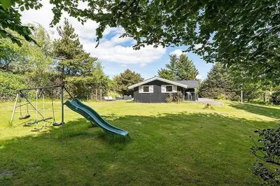 a playground with a slide in a yard at BL1052-Blokhus-Berberisvej-22 in Blokhus
