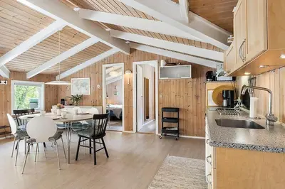 a kitchen and dining room with a table and chairs at BL1052-Blokhus-Berberisvej-22 in Blokhus