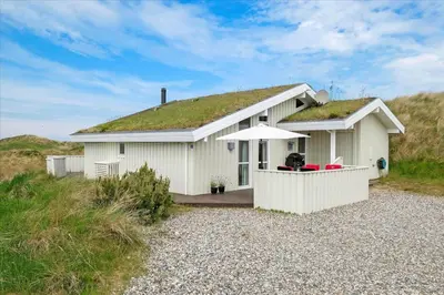 a small white house with a grass roof at BL1772-Saltum-Faarup-Klitvej-22 in Saltum