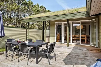 a patio with a table and chairs on a deck at BL1365-Pandrup-Hunetorp-Klitvej-69 in Pandrup