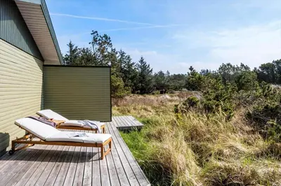a wooden deck with two lounge chairs on it at BL1365-Pandrup-Hunetorp-Klitvej-69 in Pandrup