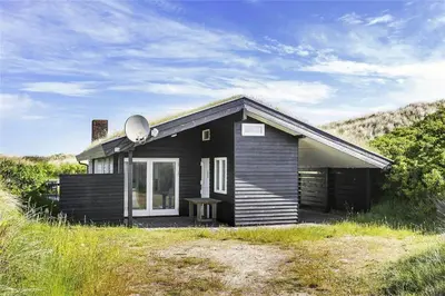 a small black house on a hill with a field at BL745-Saltum-Karen-Mariesvej-70 in Saltum