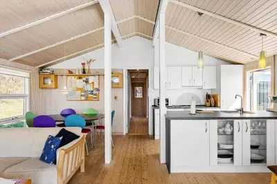 a kitchen and living room with white cabinets and a table at BL826-Saltum-Haresvinget-7 in Saltum