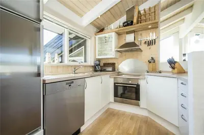 a kitchen with white cabinets and a stainless steel refrigerator at BL486-Saltum-Laustvej-32 in Saltum