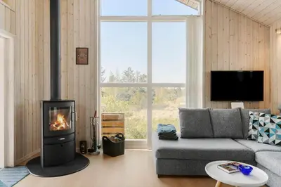 a living room with a couch and a fireplace at BL1702-Blokhus-Krylevej-3 in Blokhus