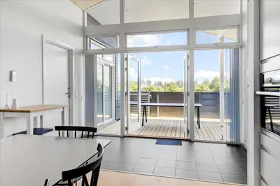 a living room with a table and chairs and a large window at BL540-Saltum-Trehoje-9 in Saltum